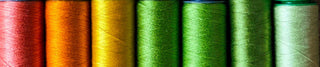 Colorful spools of thread arranged in a row.