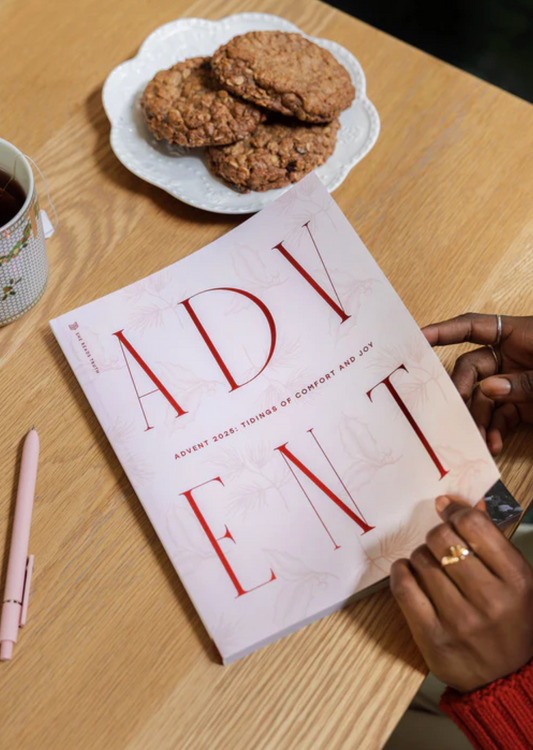 Book titled 'ADVENT' on a table with cookies and a cup of coffee.