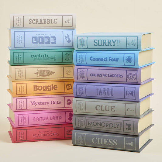 Stack of colorful board game boxes on a beige background