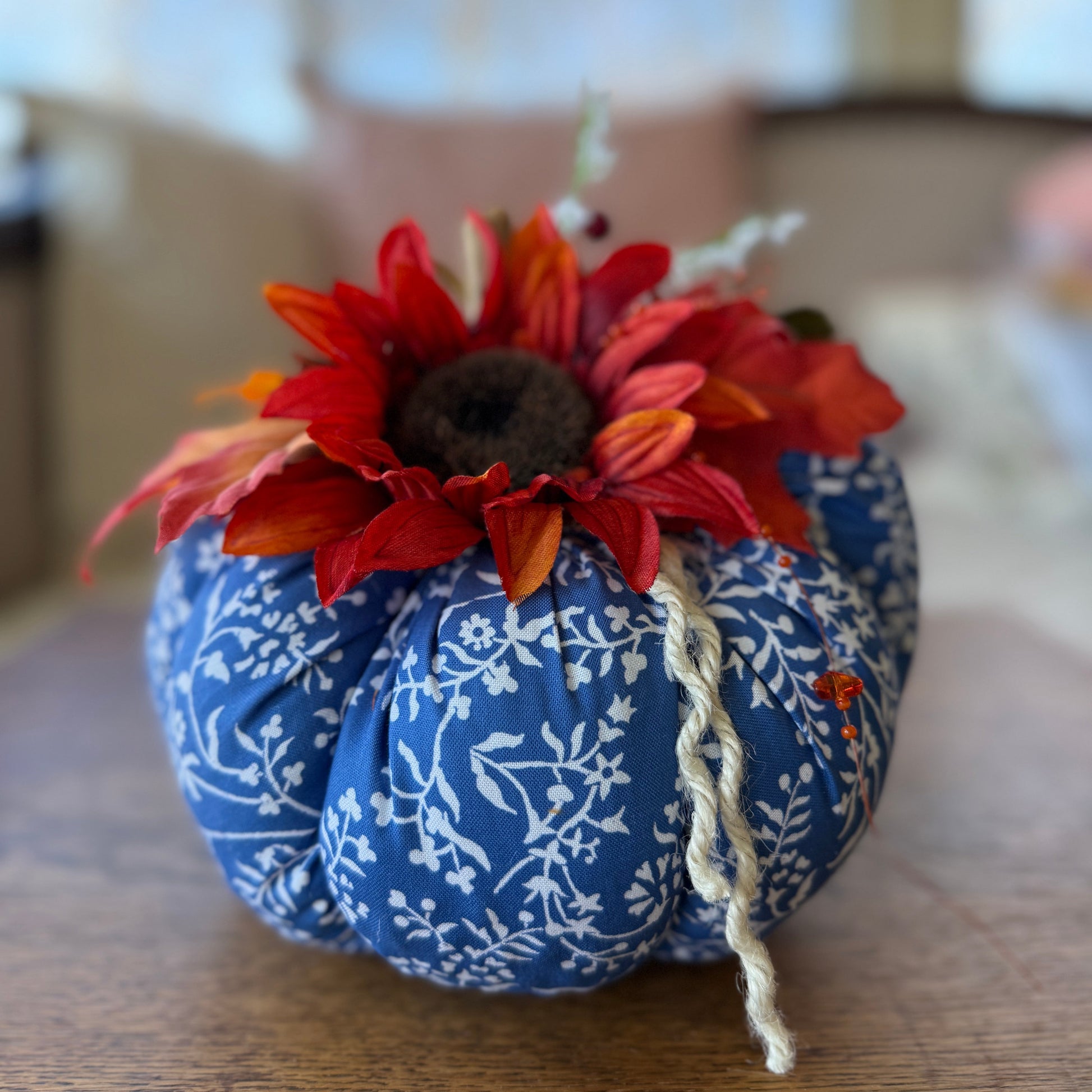 Decorative pumpkin with a sunflower on a wooden surface