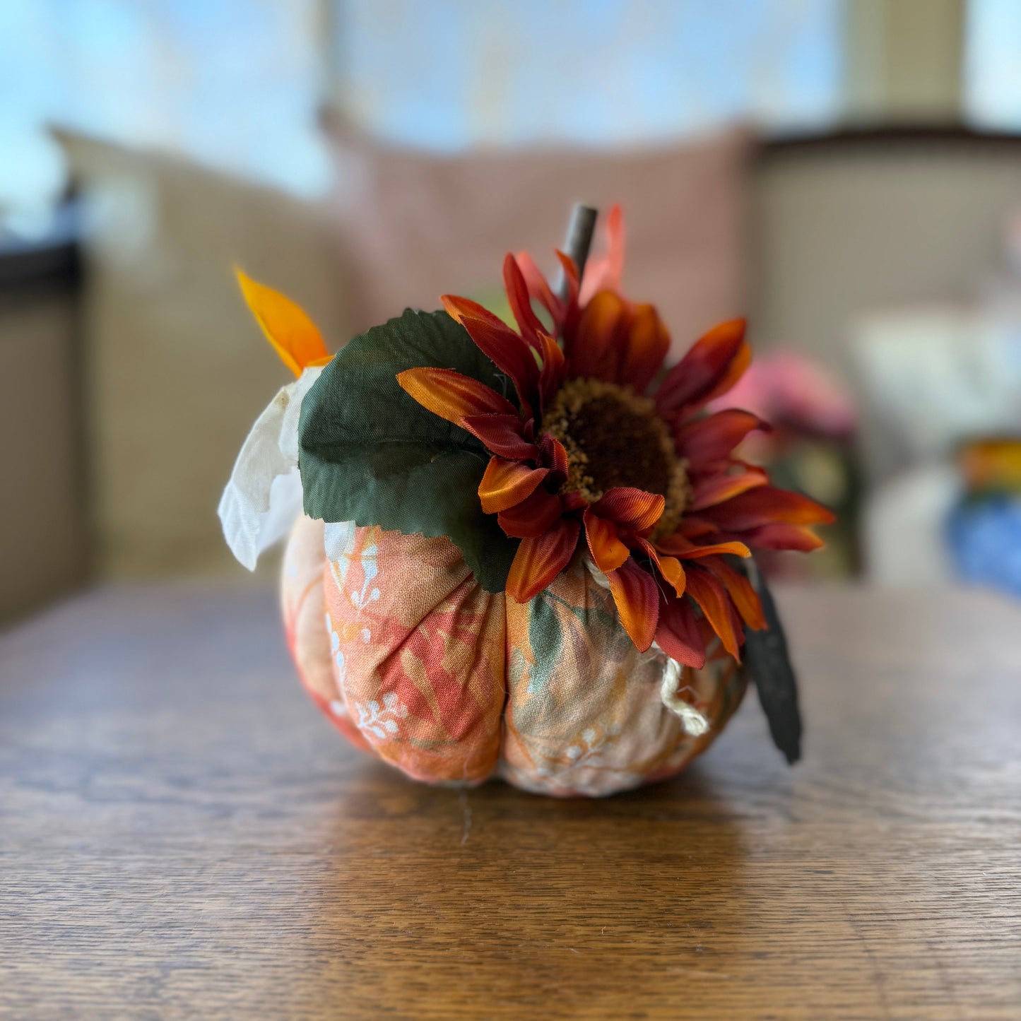 Decorative pumpkin with a sunflower on a wooden table