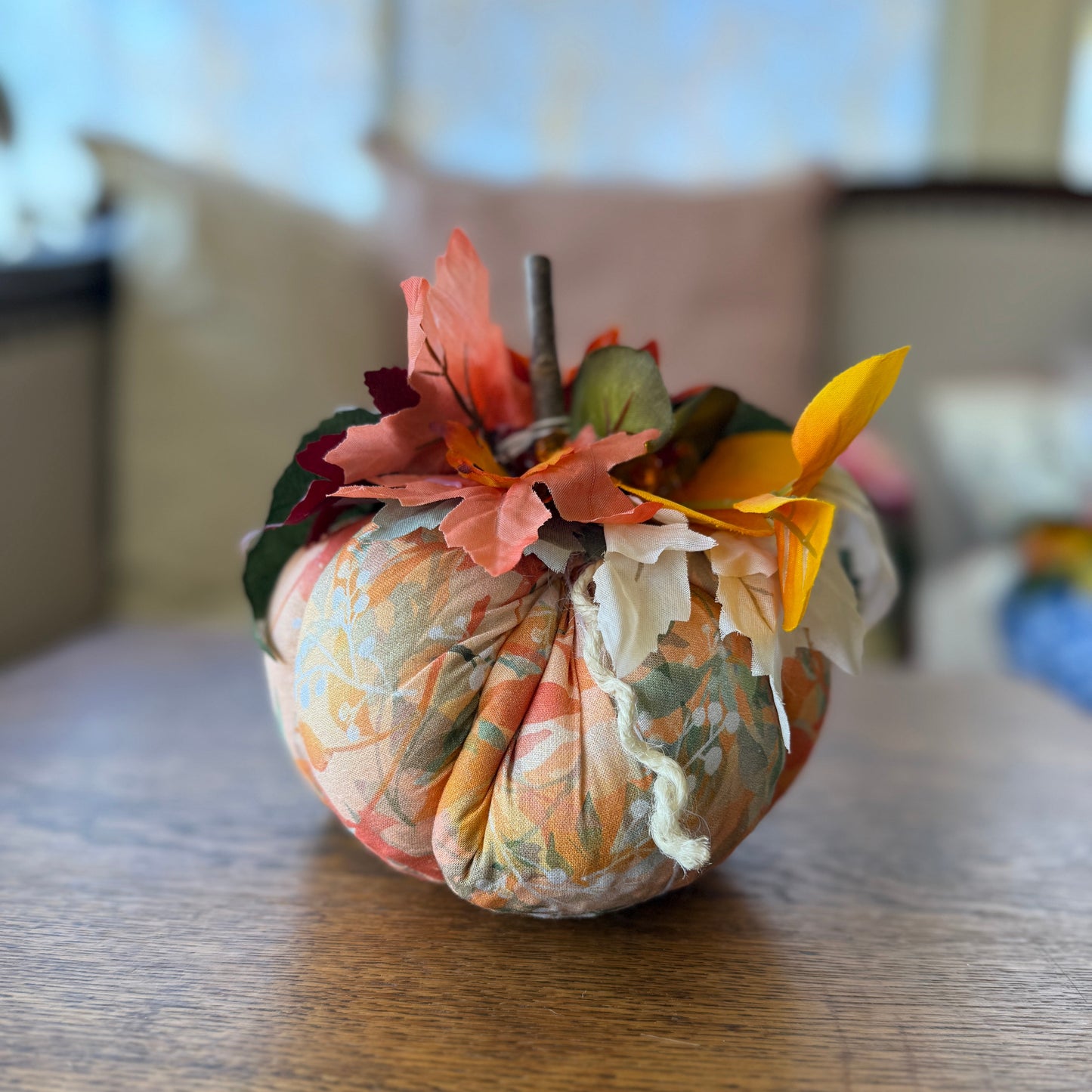 Decorative pumpkin with floral fabric on a wooden table