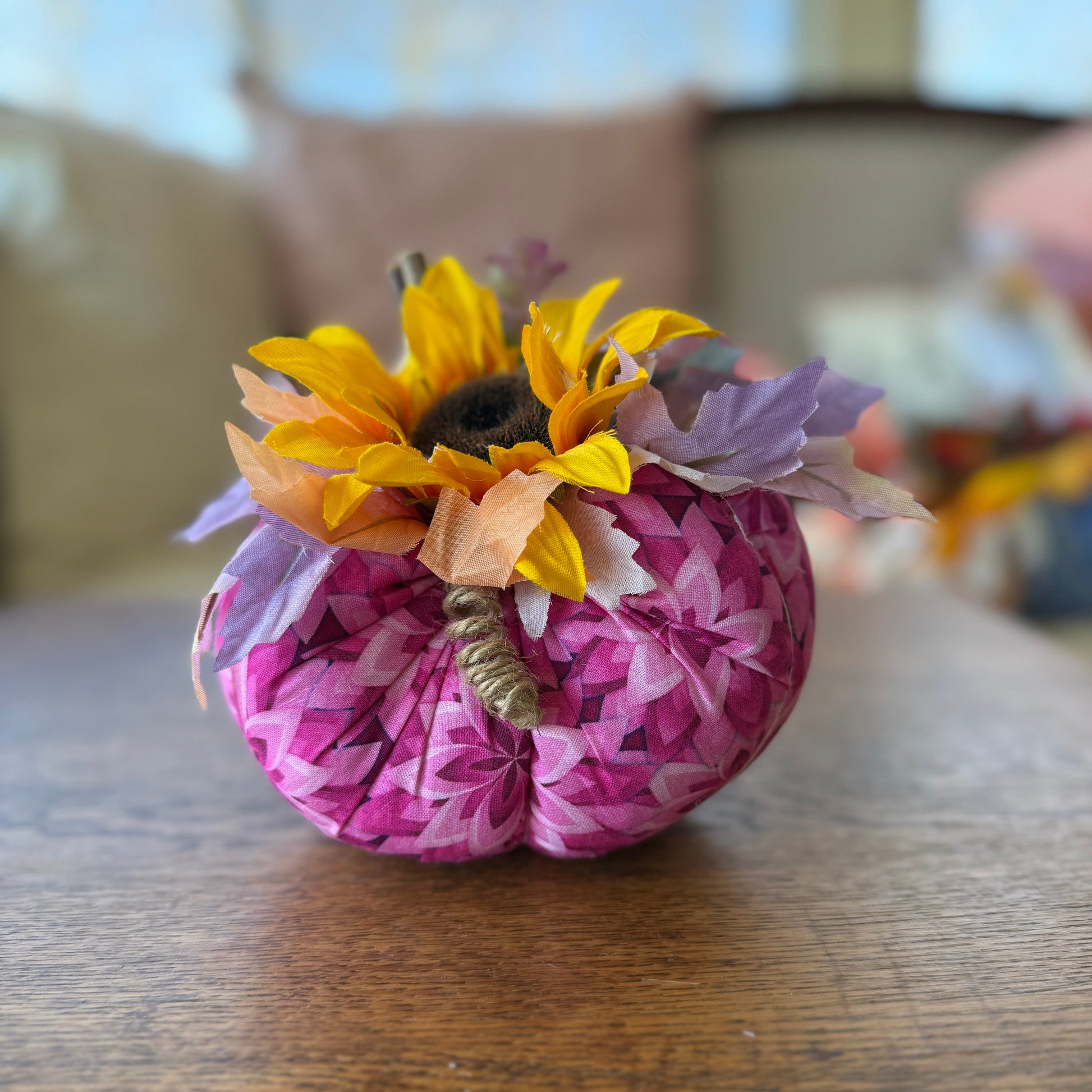 Decorative pumpkin with floral decorations on a wooden surface