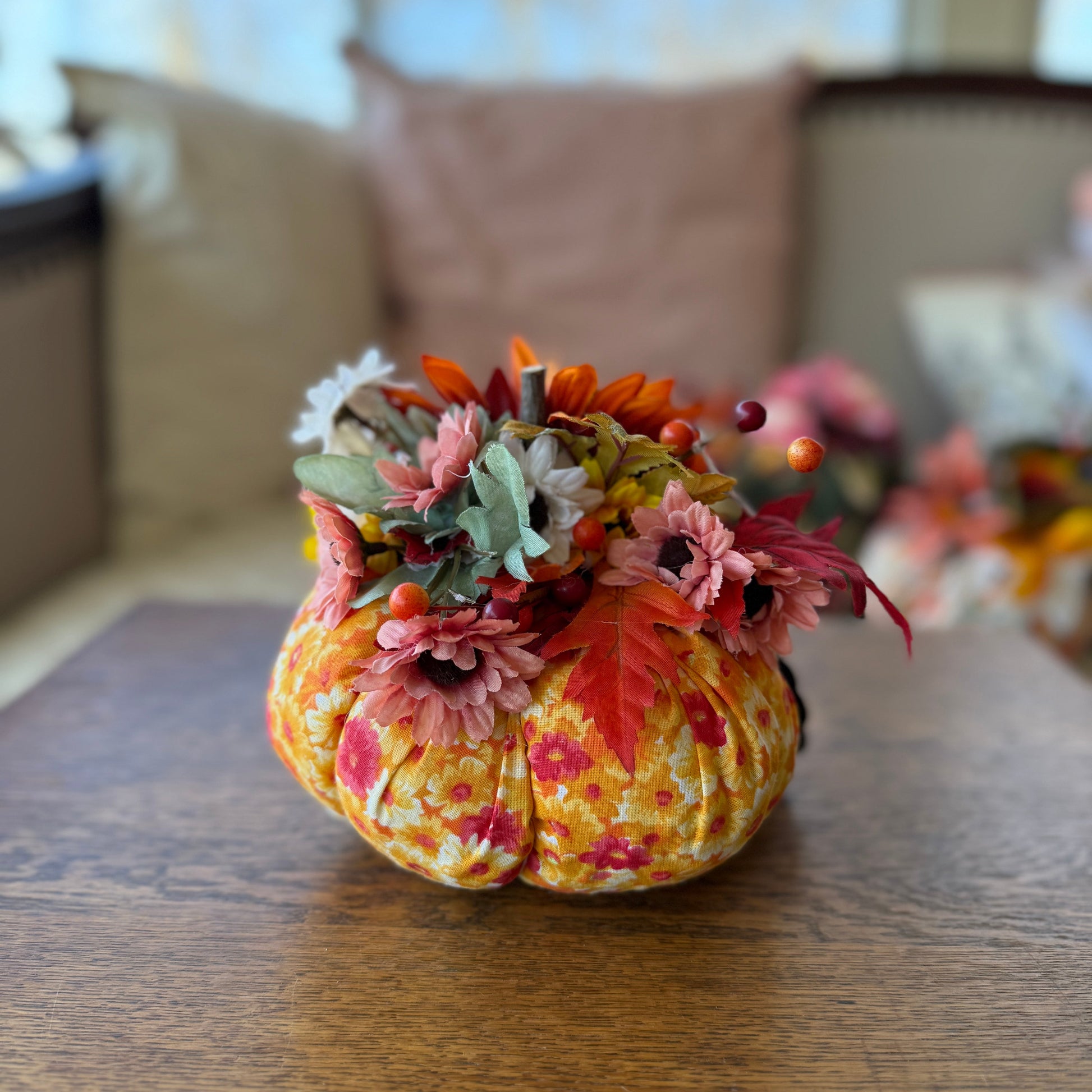 Decorative pumpkin with flowers on a wooden table