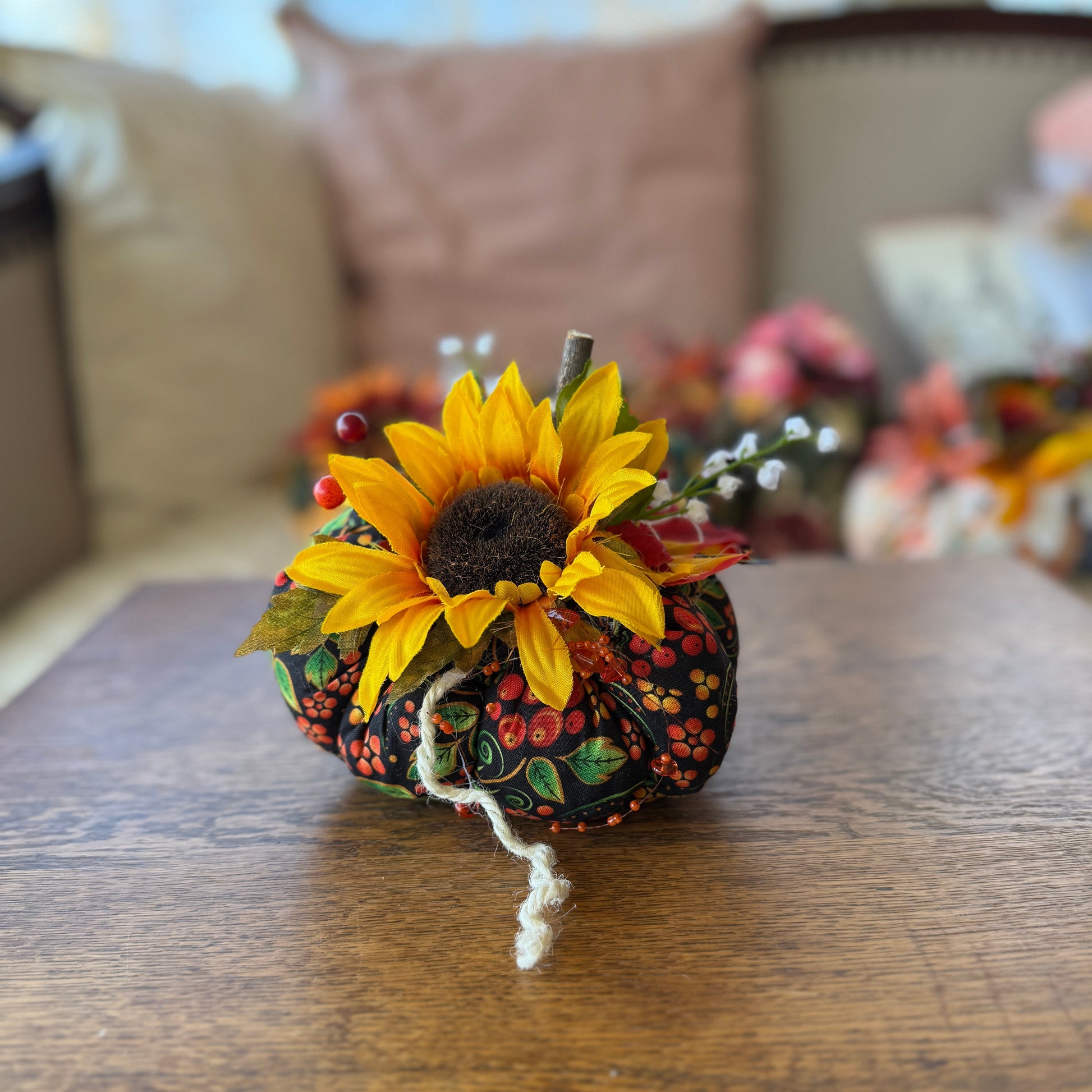 Decorative pumpkin with a sunflower on a wooden table